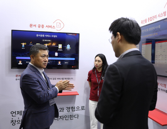 마용득 롯데정보통신 대표(왼쪽)가 16일 서울 삼성동 코엑스에서 열린 '블록체인 서울 2019'에 전시된 자사 솔루션을 둘러보고 있다. 롯데정보통신은 화학물 이동추적 관리, 축산물 종합관리 등 솔루션을 선보였다.  롯데정보통신